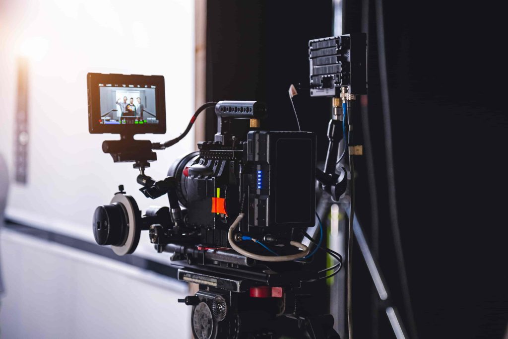 A professional film crew from a Chicago Video Production Company filming an interview in a modern corporate office setting.