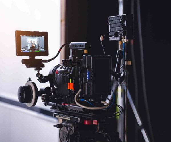 A professional film crew from a Chicago Video Production Company filming an interview in a modern corporate office setting.