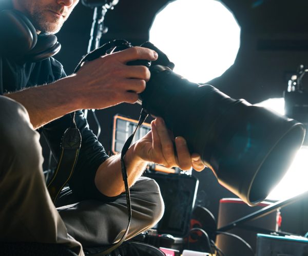 Caucasian Photographer with Modern Camera and Telephoto Lens Attached