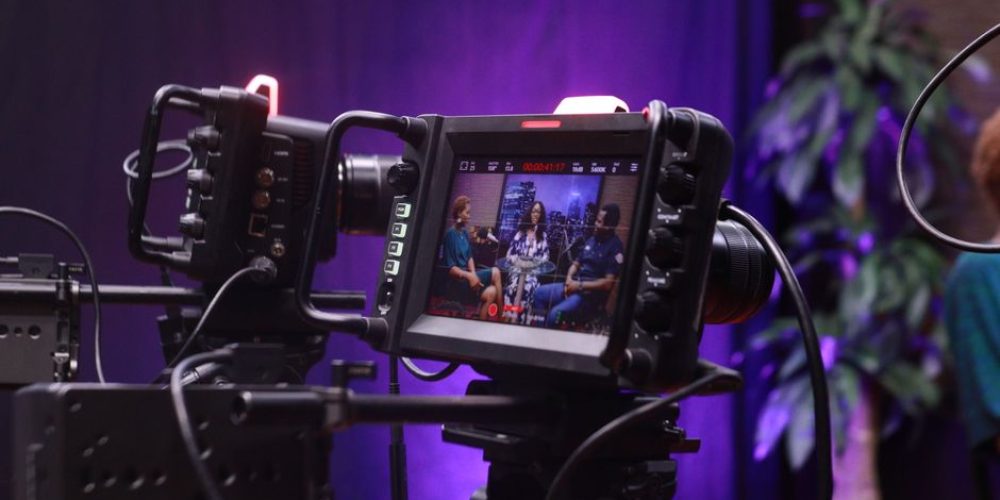 Two-person interview lighting setup with cross-key LED panels on a corporate video shoot