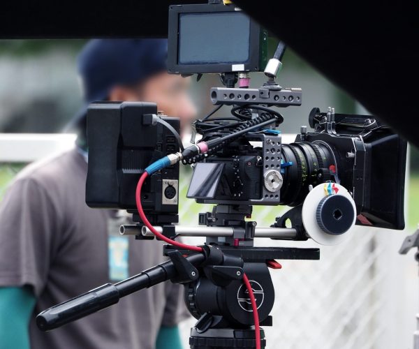 Video camera in film or movie production on tripod and professional gear which shooting in location or studio with crew team and beautiful prop or set and ready to online live broadcast or tv on air later