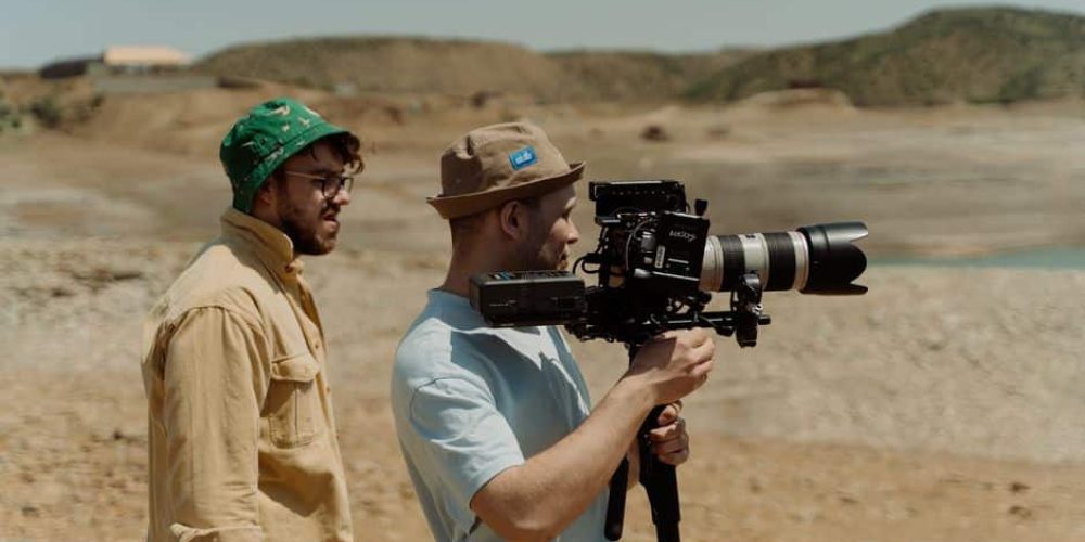 Videographer offloading and organizing footage on a laptop during a professional video production shoot